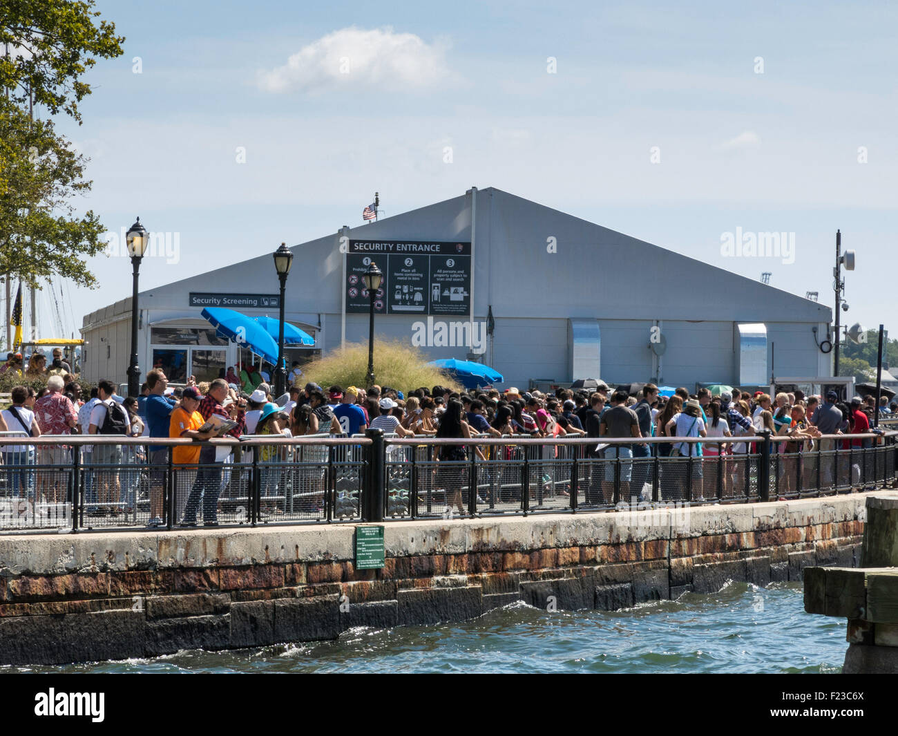 Lungo le linee in corrispondenza di una zona di protezione per il traghetto per Liberty Island, Battery Park, New York, Stati Uniti d'America Foto Stock