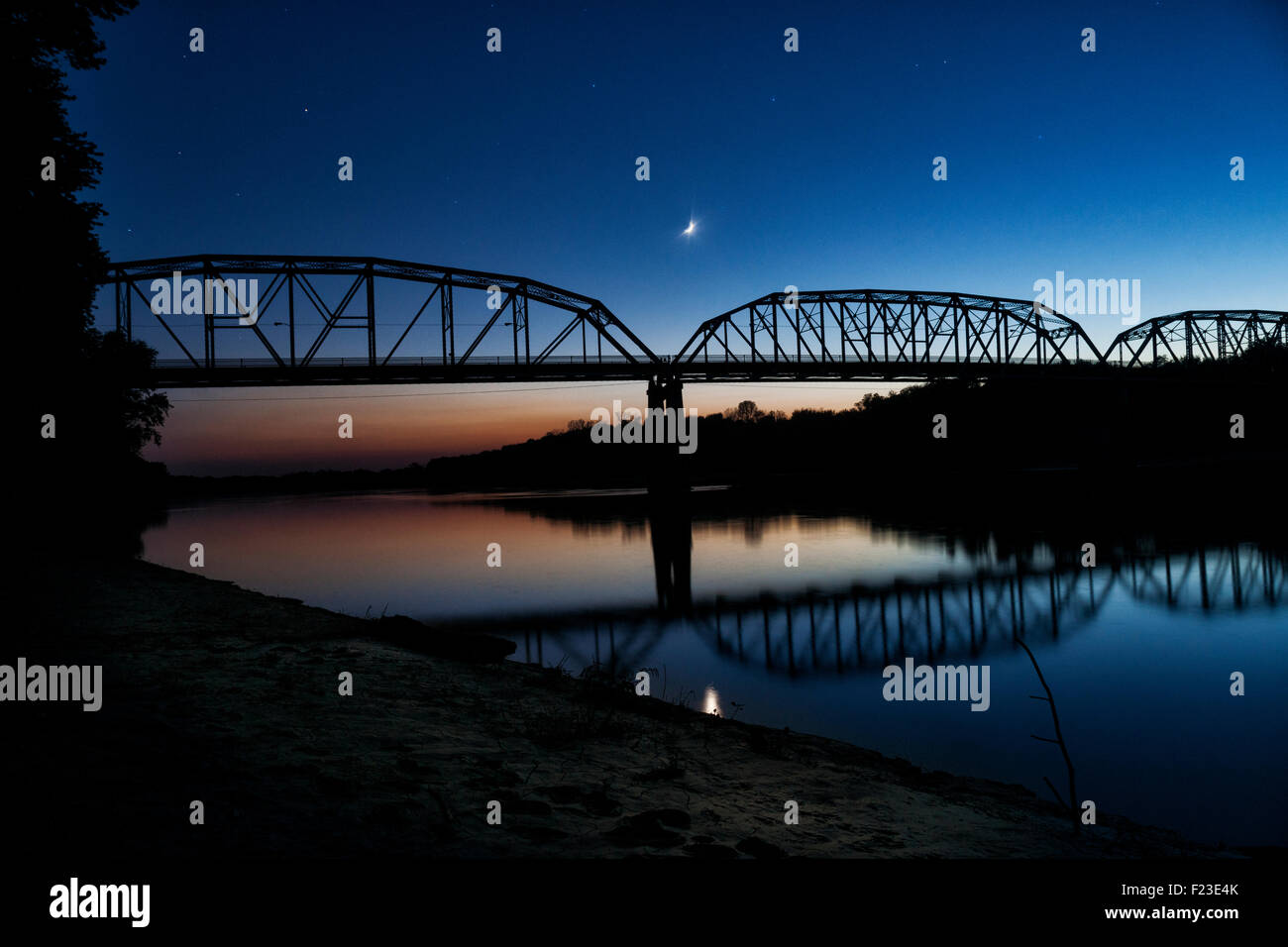 Cieli notturni con colore arancio i trend con orizzonte di riferimento e la mezza luna nel cielo sopra un ponte sopra il fiume Wabash, nuova armonia, IN, STATI UNITI D'AMERICA Foto Stock