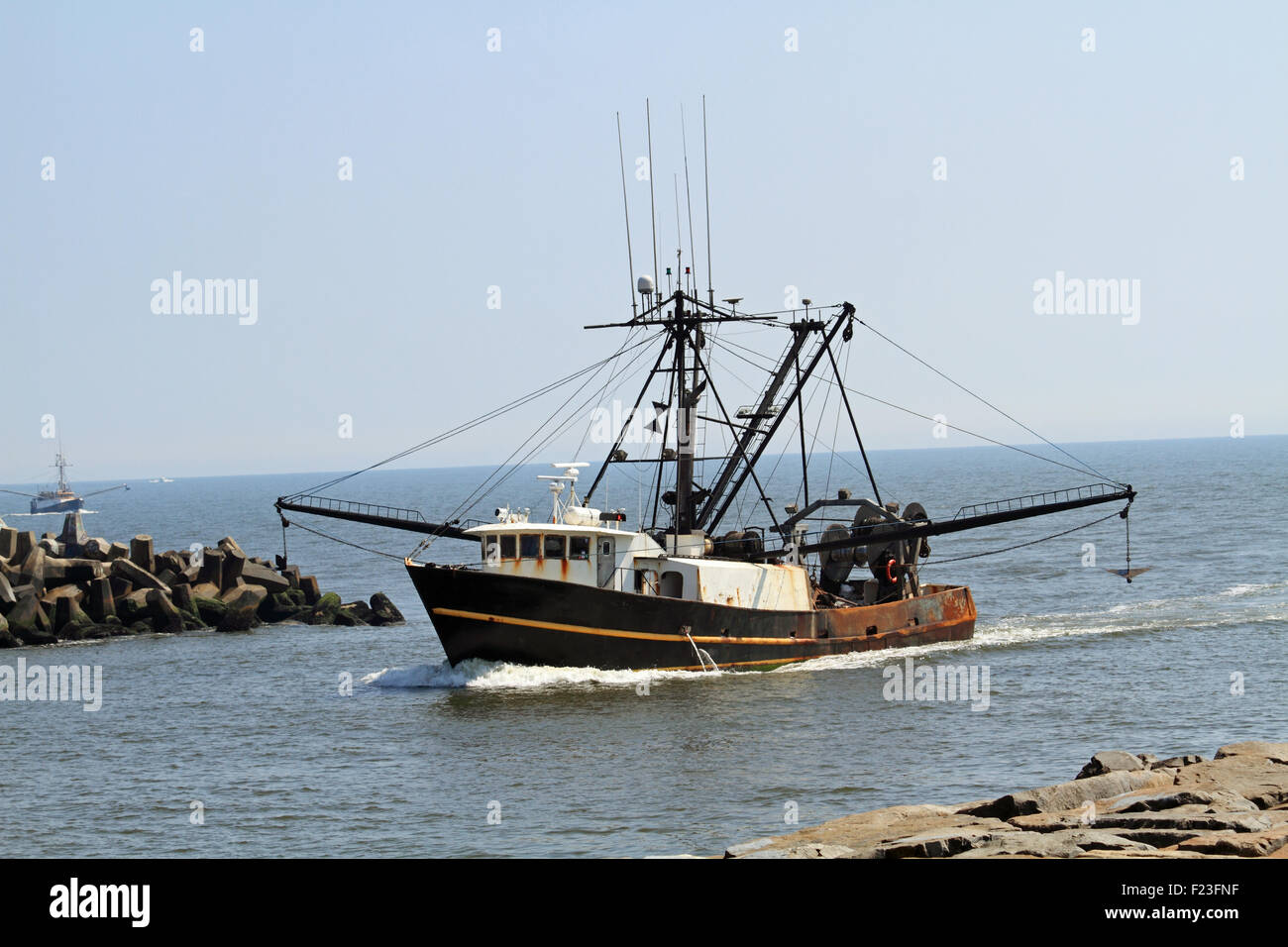 Un commerciale peschereccio di ritorno dal lavoro e in procinto di entrare nell'ingresso Manasquan al punto piacevole, New Jersey, STATI UNITI D'AMERICA Foto Stock