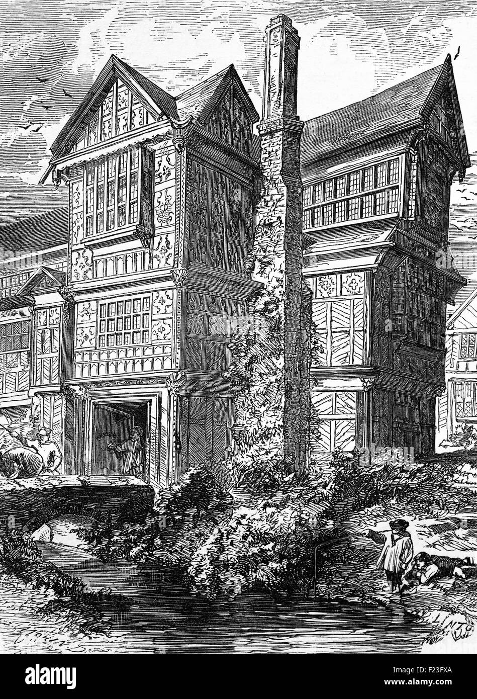 Bambino la pesca nel fossato di un raffinato stile Tudor Hall di un inglese scudiero. Foto Stock