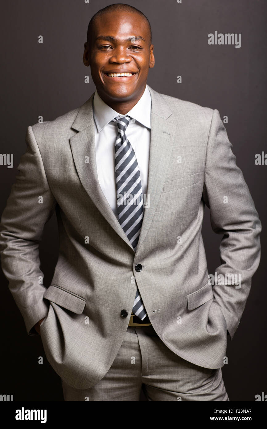 Allegro giovane africano business executive su sfondo nero Foto Stock