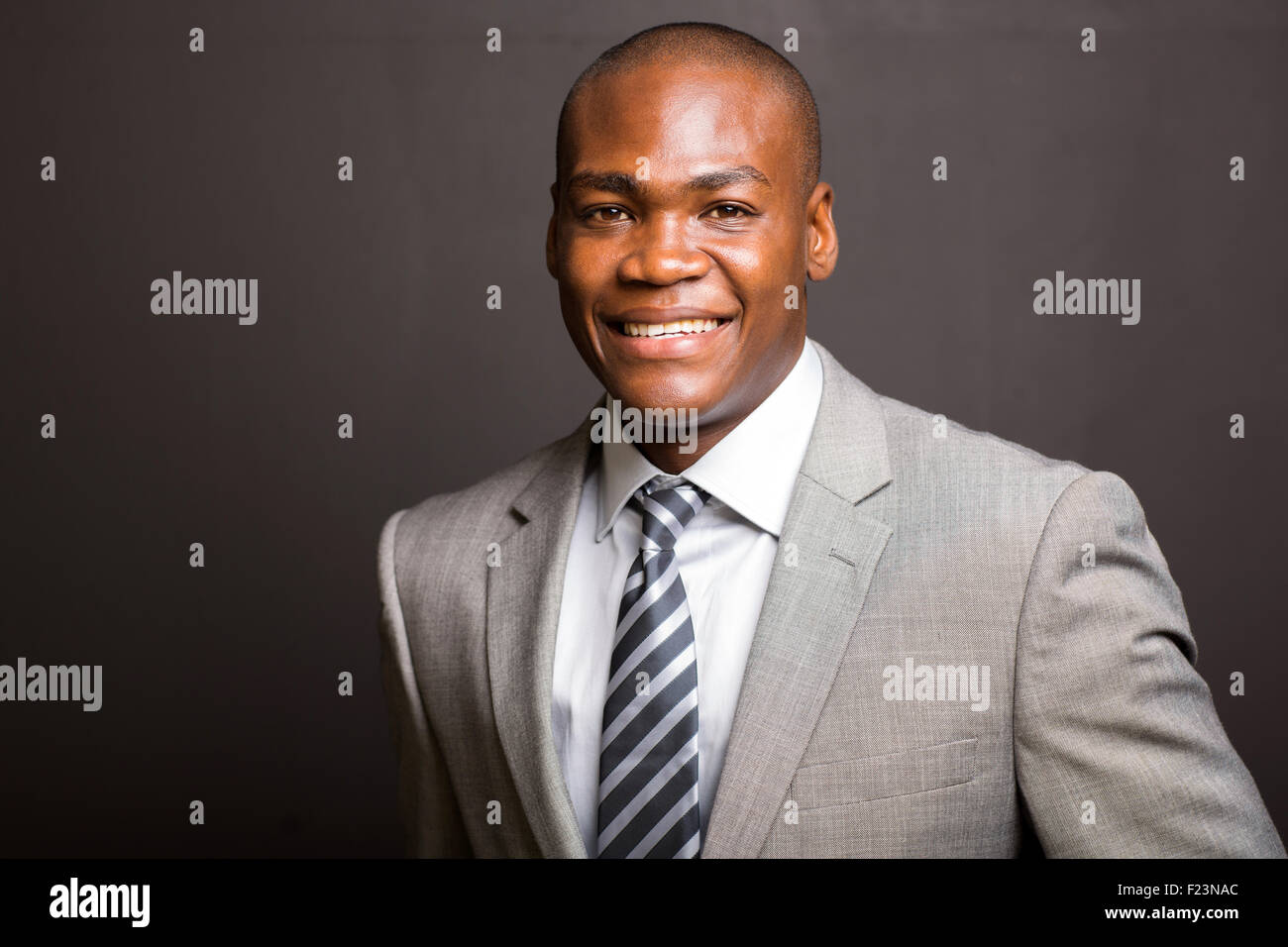 Ritratto di giovane uomo d affari in piedi su sfondo nero Foto Stock