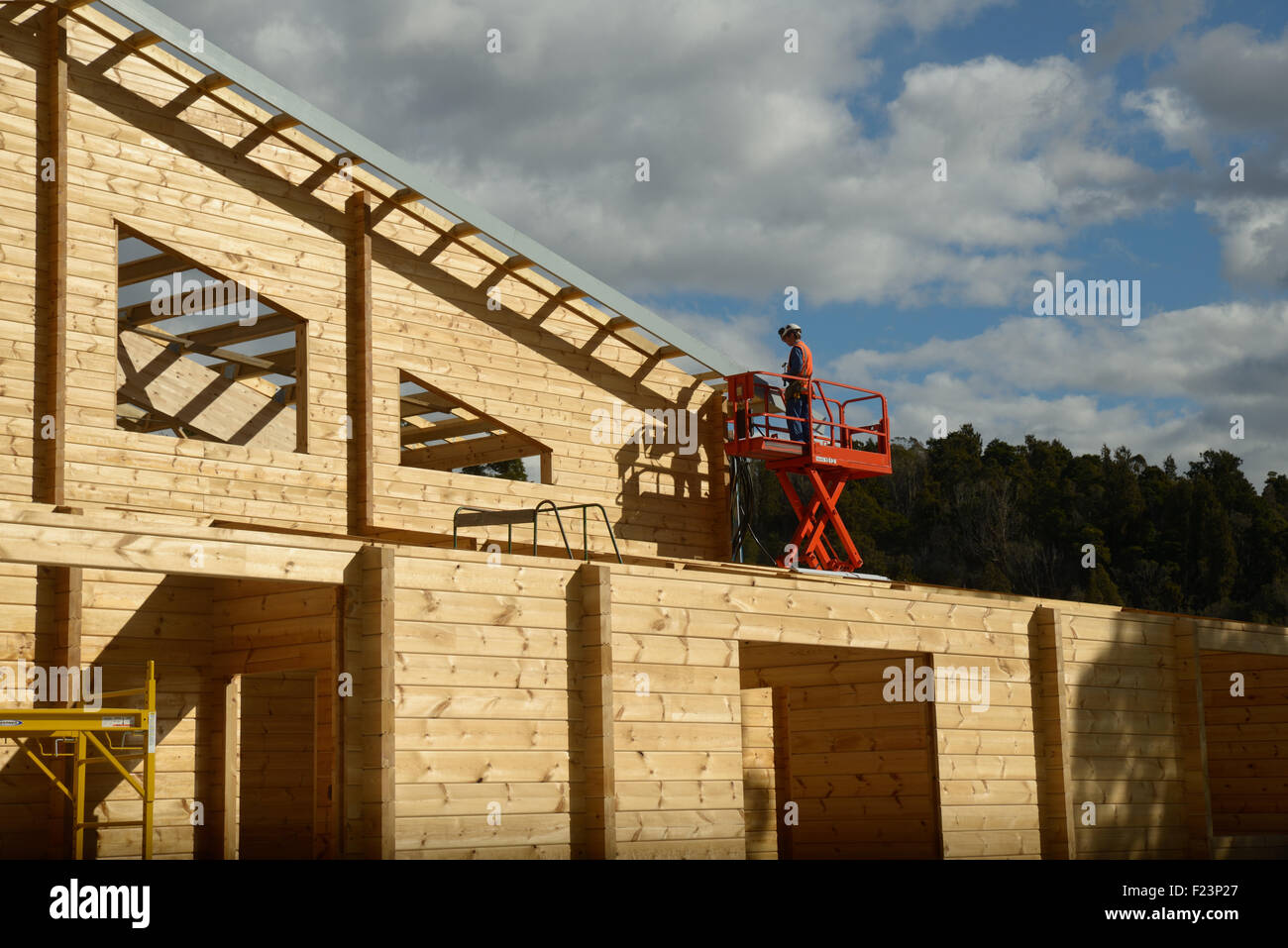 Un builder attribuisce lavoro a rete di filo per un edificio in preparazione per la messa sul tetto Foto Stock