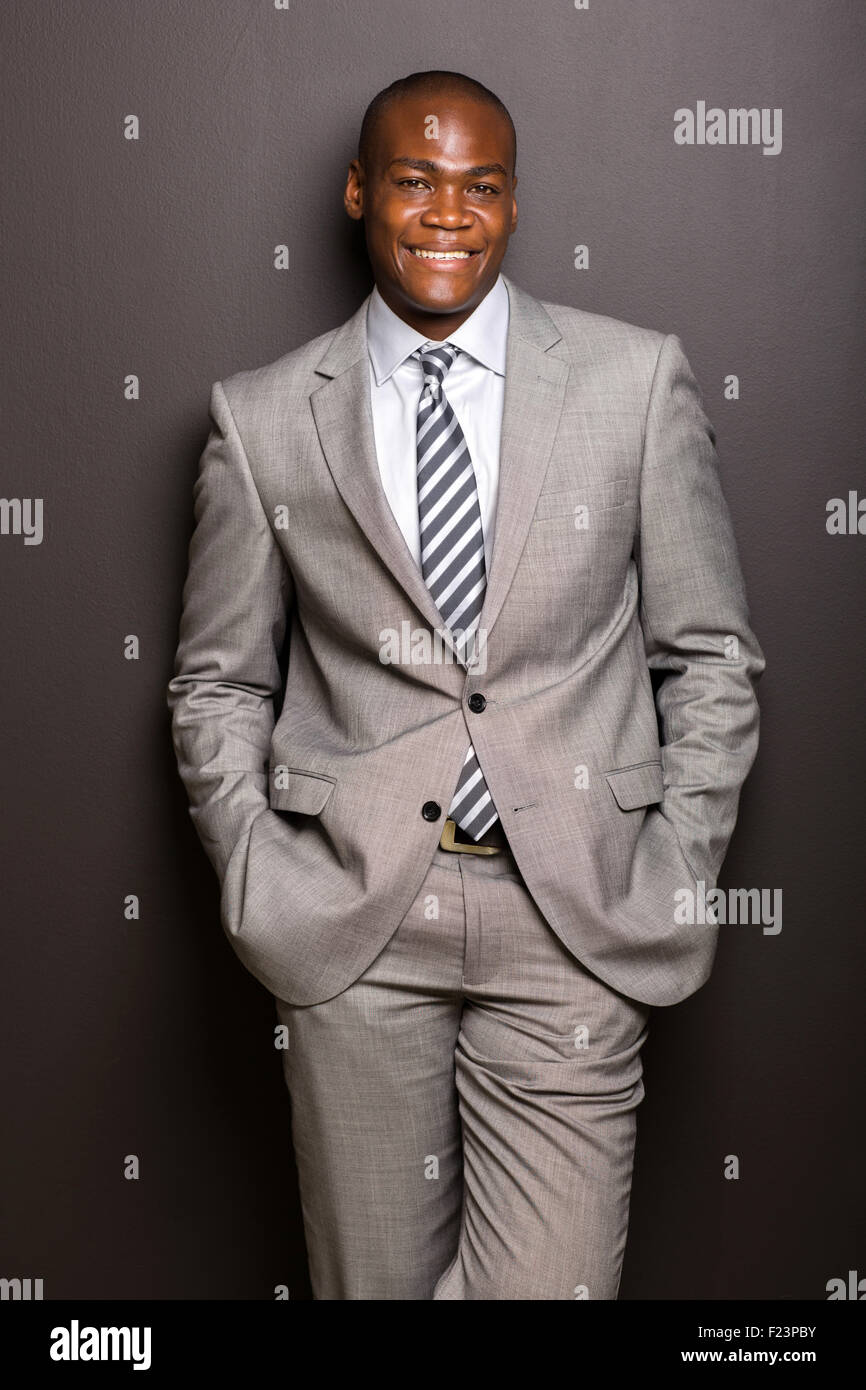 Ritratto di African American uomo in piedi contro il muro nero Foto Stock