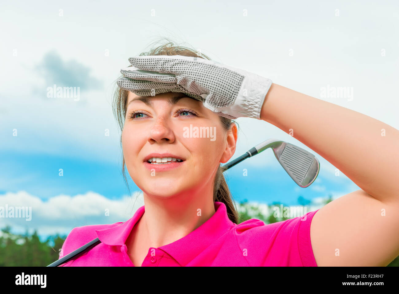 Donna golfista guardando fuori per sfere volanti Foto Stock