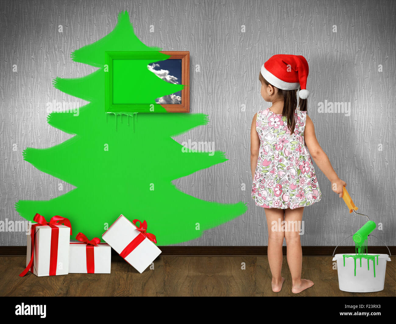 Funny bambino vestito Santa hat, attira l albero di Natale sulla parete di casa, concetto di natale Foto Stock