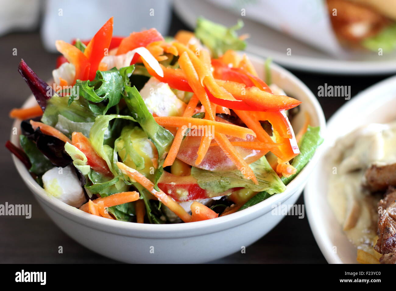 Una ciotola di insalata greca in un bianco ciotola con feta di oliva cipolla pomodoro Foto Stock