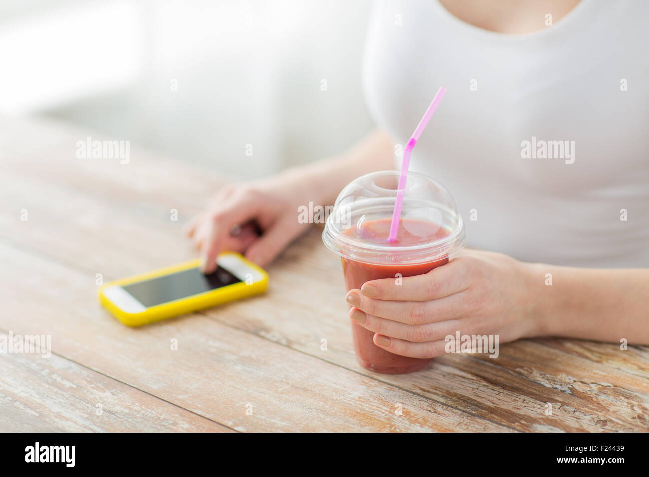 Close up di donna con smartphone e frullati Foto Stock