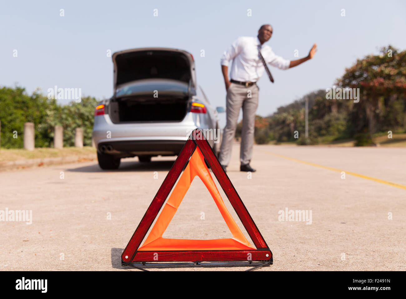 L'uomo africano in cerca di aiuto dopo un guasto auto a lato della strada Foto Stock