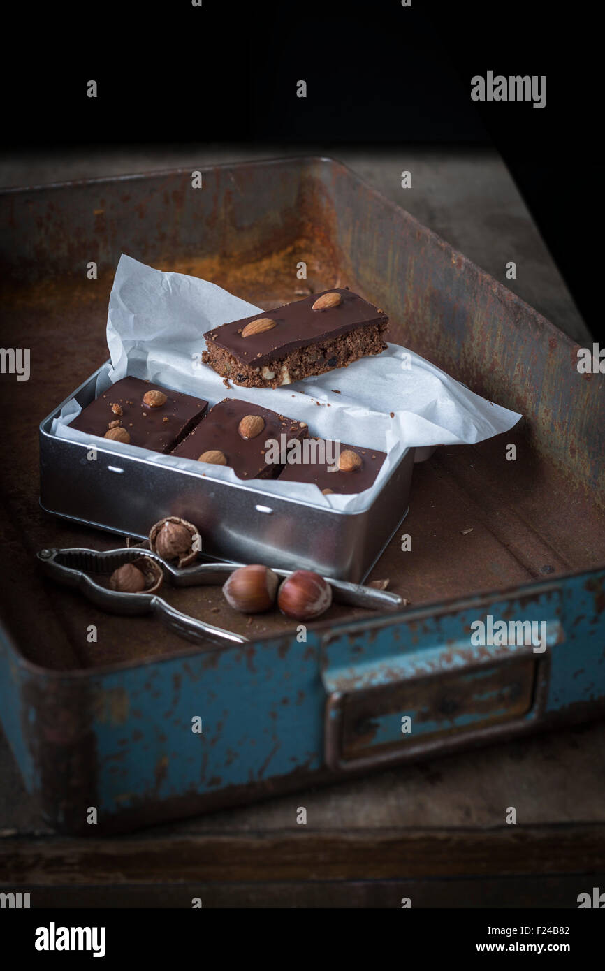 Gingerbead con ricchi di cioccolato e mandorle in aprire la casella color argento con dadi e schiaccianoci Foto Stock
