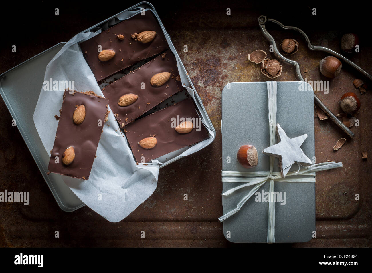 Gingerbead con ricchi di cioccolato e mandorle in aprire casella di argento e una scatola avvolto con nastro. Vista superiore Foto Stock