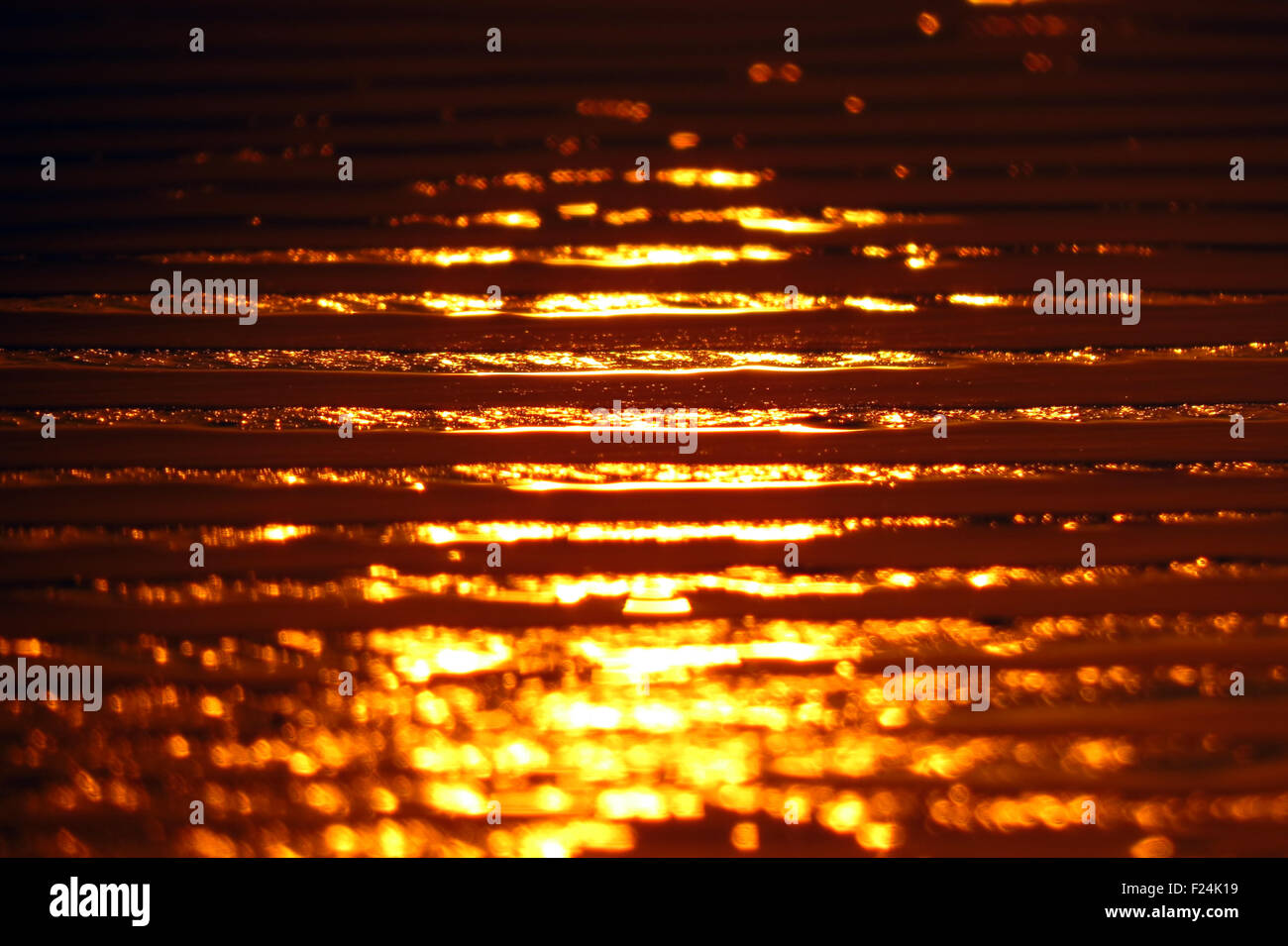 Sfondo di una spiaggia di sabbia con pattern di riflessione dell'impostazione golden sun Foto Stock