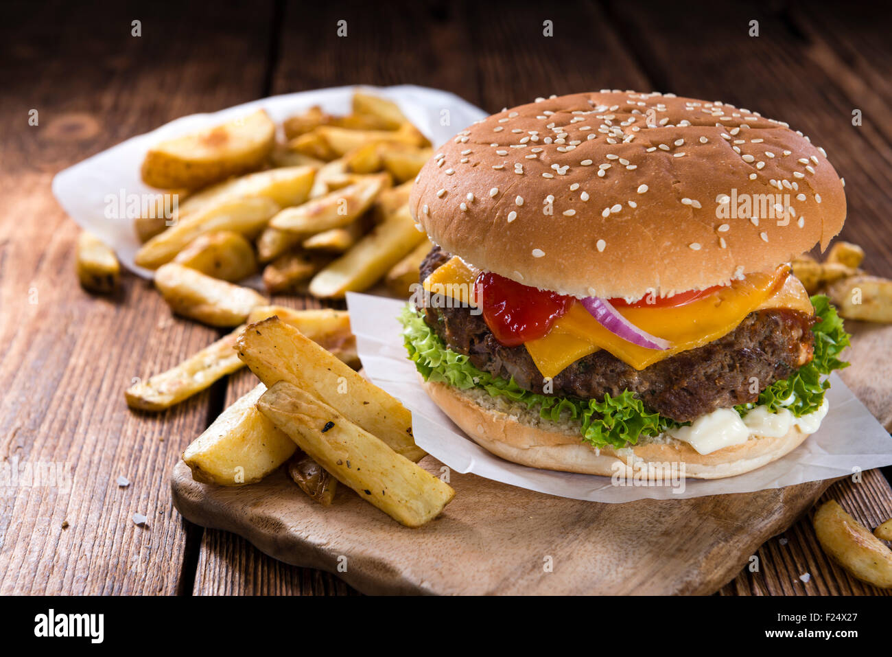 In casa hamburger di manzo con formaggio e chip su sfondo di legno Foto Stock