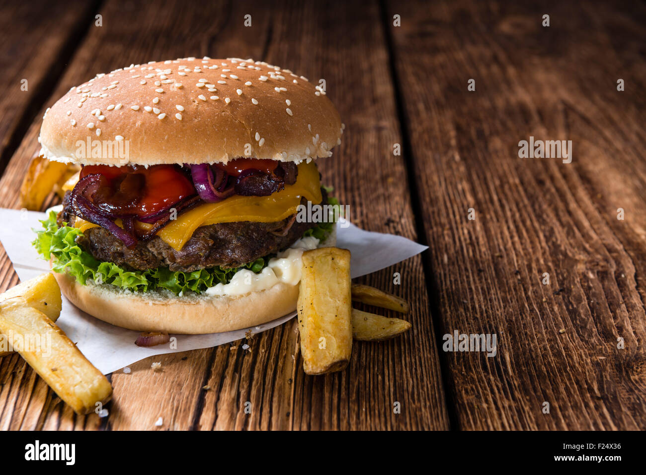 In casa hamburger di manzo con formaggio e chip su sfondo di legno Foto Stock