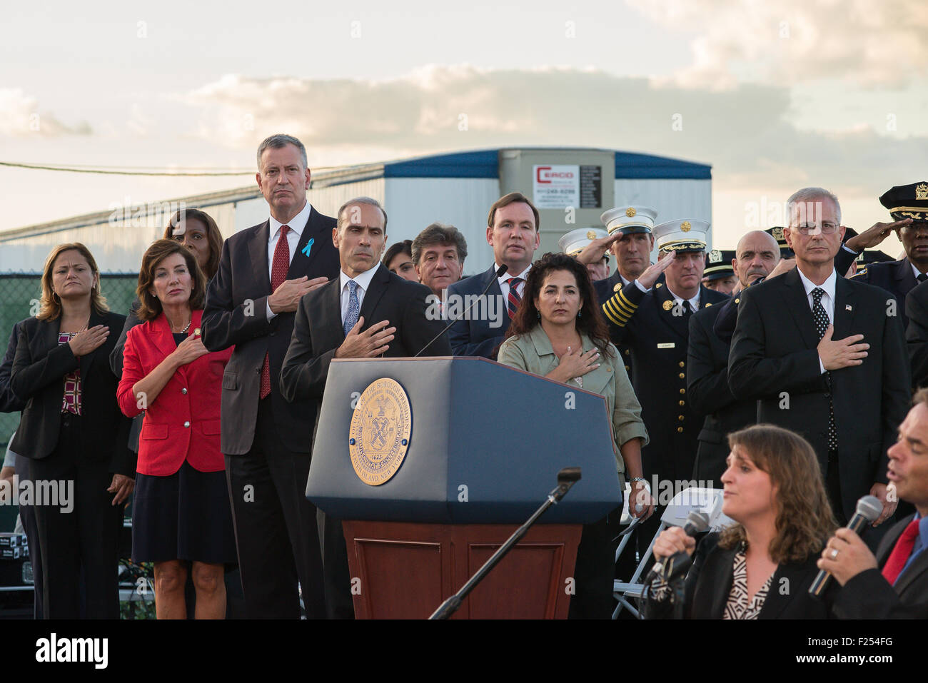 La Staten Island, Stati Uniti. Undicesimo Sep, 2015. I funzionari della città di stand per il canto dell'inno nazionale alla cerimonia di commemorazione.NYC funzionari compreso il sindaco Bill de Blasio (L) e Staten Island Borough Presidente Giacomo Oddo (2L) ha partecipato ad una cerimonia di commemorazione per la 274 Staten Island residenti che sono morti in un attacco al World Trade Center. Credito: Albin Lohr-Jones/Pacific Press/Alamy Live News Foto Stock