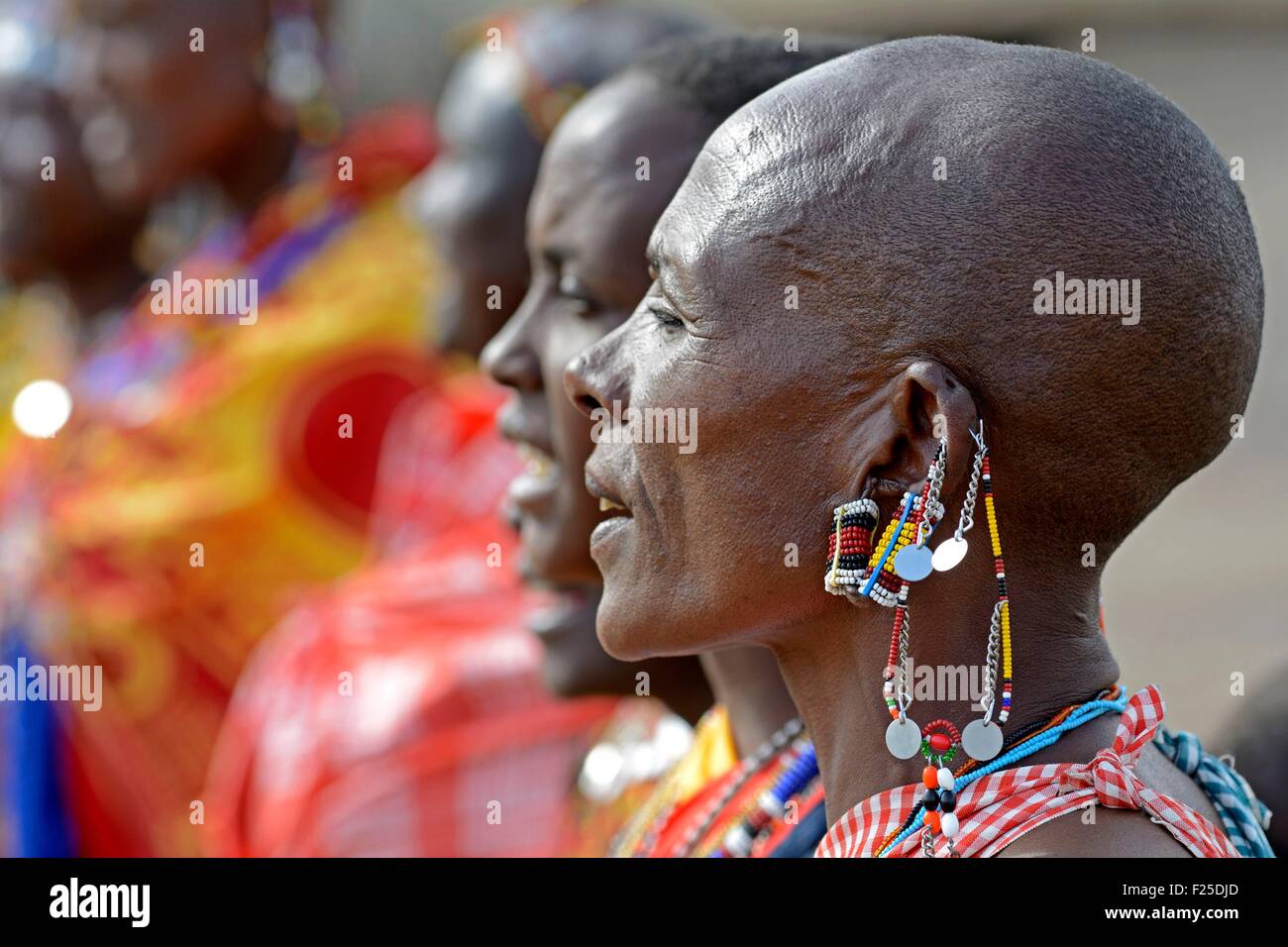 Kenia Masai Mara riserva Masai donne eseguendo un tradizionale benvenuto canzone dei Maasai in un villaggio vicino di testa jeweled Foto Stock