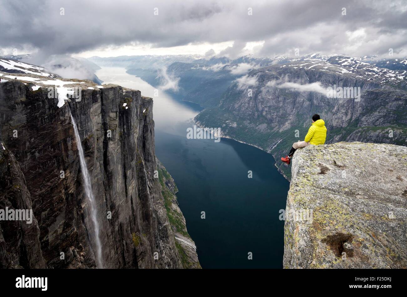 Norvegia, Rogaland, Lysefjord, Kjerag (Kiragg), escursionista guardare il fiordo 1000m al di sotto di Foto Stock