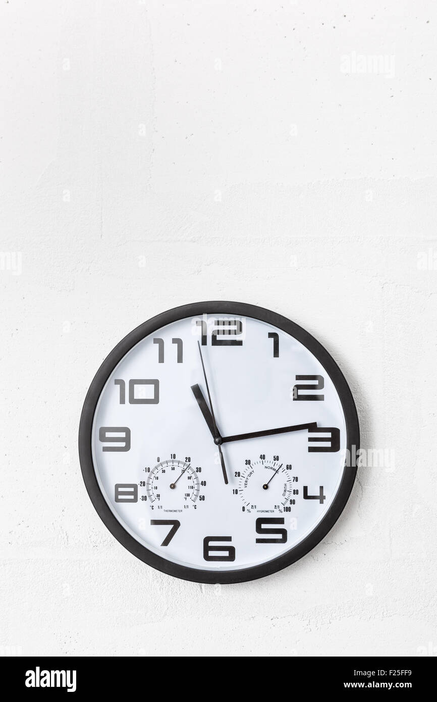 Grande tondo nero orologio sul muro bianco. Foto Stock