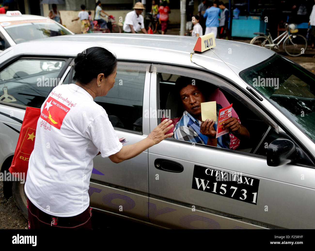 Yangon, Myanmar. Xii Sep, 2015. Un membro della Lega nazionale per la democrazia (NLD) partito distribuisce pamphlet di campagna del partito NLD sulla strada a Yangon, Myanmar, Sett. 12, 2015. Myanmar su tutto il territorio nazionale della campagna elettorale ha preso slancio dato che è iniziato martedì a Yangon, Nay Gen. Pyi Taw e Mandalay città così come alcune altre cittadine in regioni e stati. © U Aung/Xinhua/Alamy Live News Foto Stock