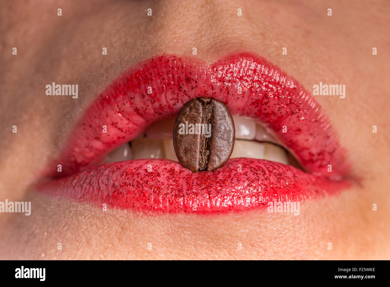 I chicchi di caffè tra le labbra Foto Stock