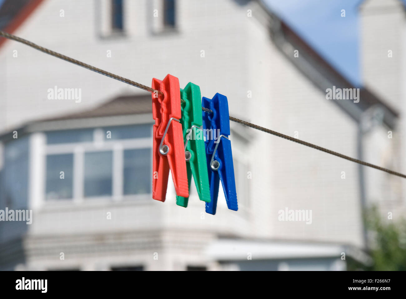 Tre colorate clothespins domestici sulla linea di abbigliamento Foto Stock