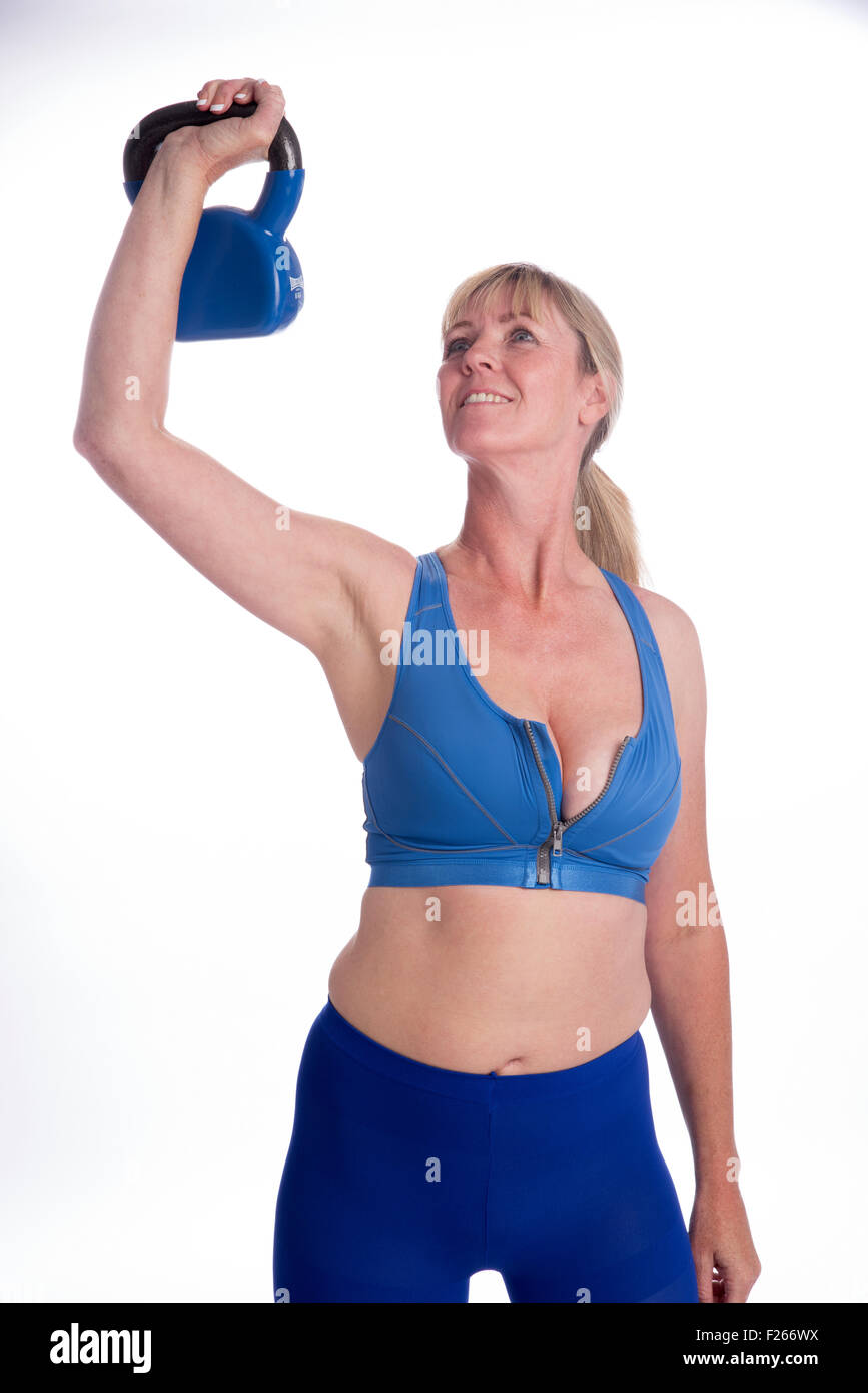 Donna esercizio con un peso kettlebell in palestra Foto Stock