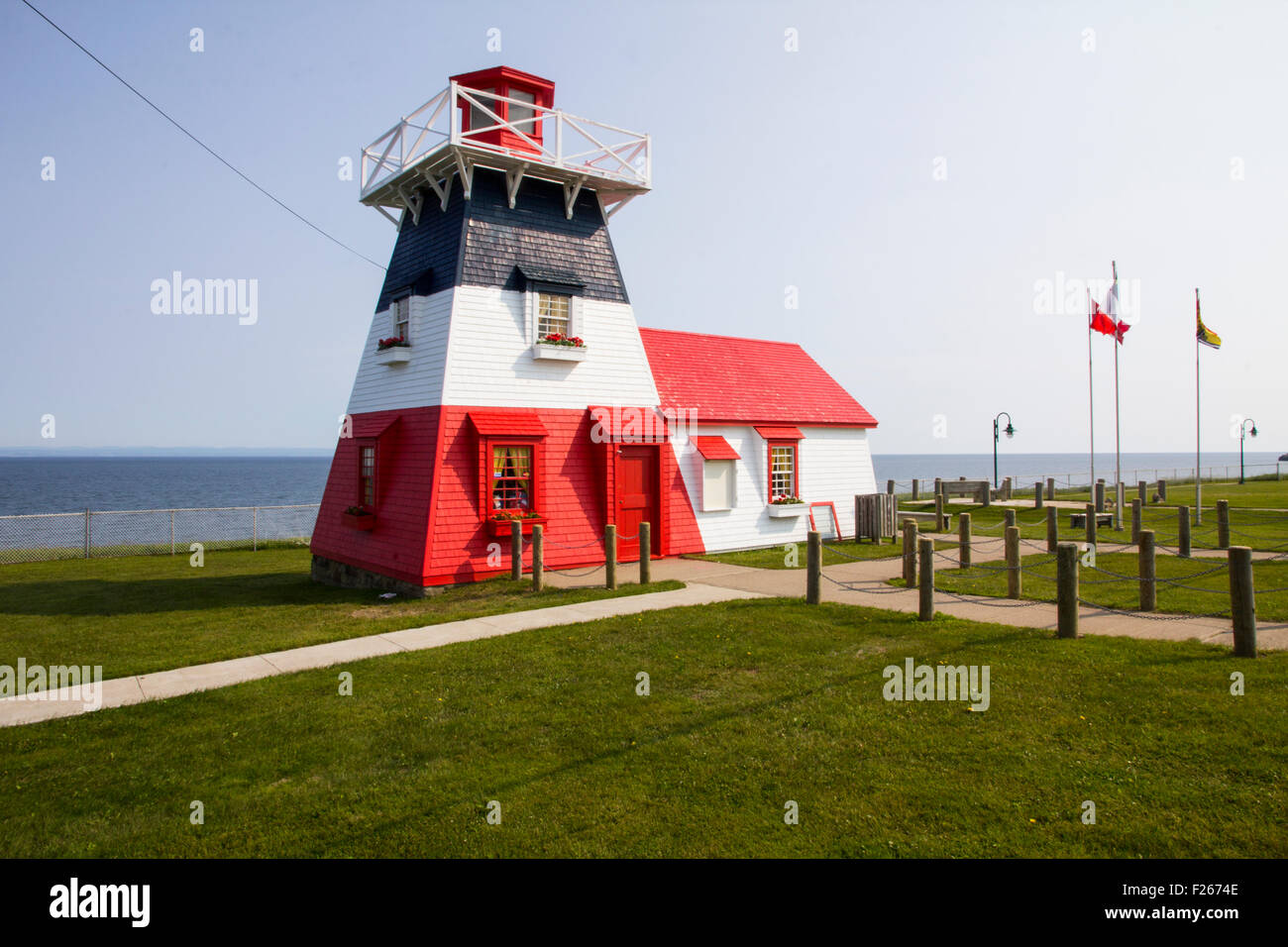 Il legno 1914 Grande Anse Faro (verniciato nei colori della bandiera Acadian) in Grande Anse, New Brunswick, Canada. Foto Stock