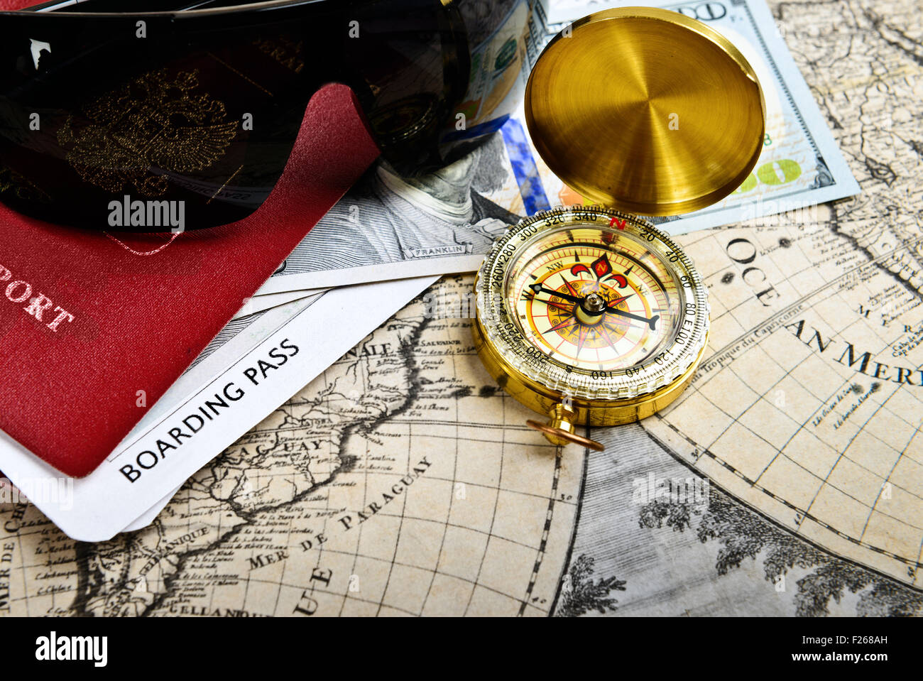 Articoli di viaggio passaporto, bussola, biglietto, denaro, gli occhiali da sole sul molto vecchia parola mappa. Il concetto di viaggio Foto Stock