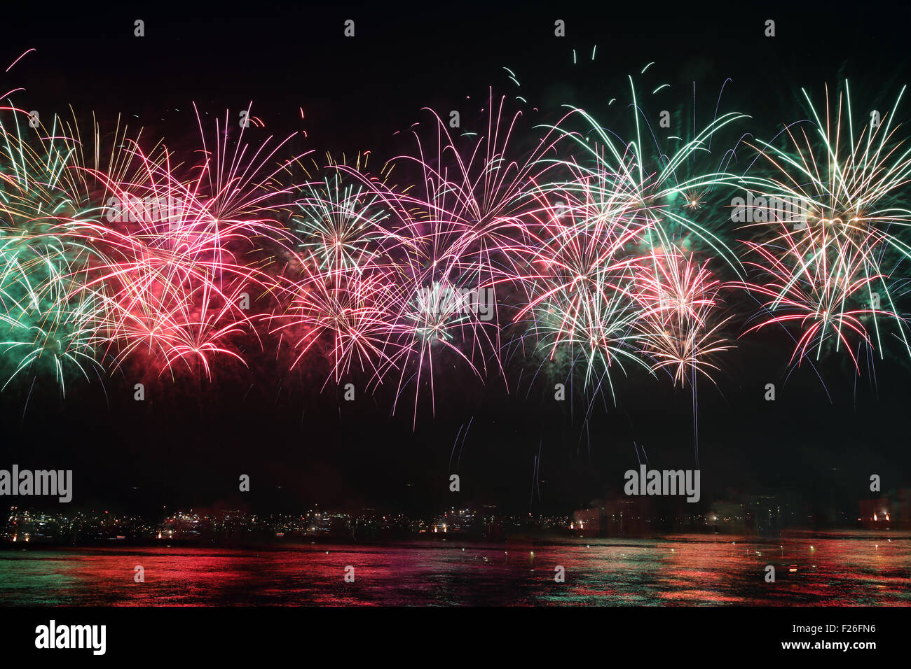 Coloratissimi fuochi d'artificio riflettere su acqua di mare Foto Stock