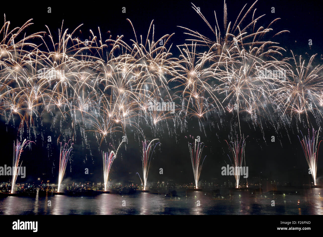 Coloratissimi fuochi d'artificio riflettere su acqua di mare Foto Stock