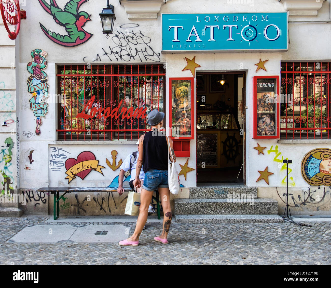 Loxodrom salotto tattoo, shop esterno con vernice colorata e tatuati giovane uomo cercando nella finestra, Kastanienallee, Berlino Foto Stock