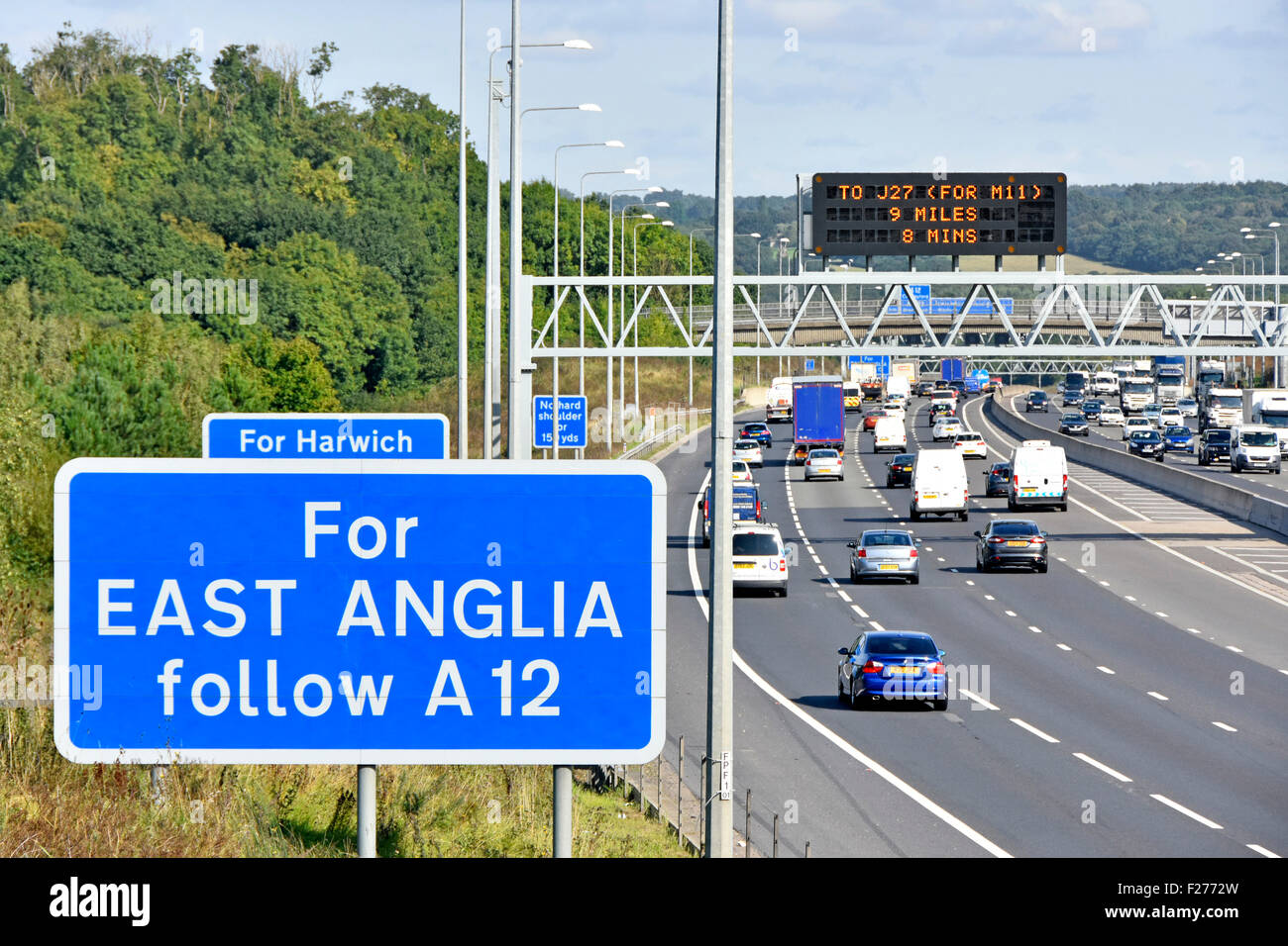 M25 Autostrada gantry elettronici montati sul segno di informazioni con le tradizionali blu indicazioni stradali per East Anglia route Brentwood Essex England Regno Unito Foto Stock