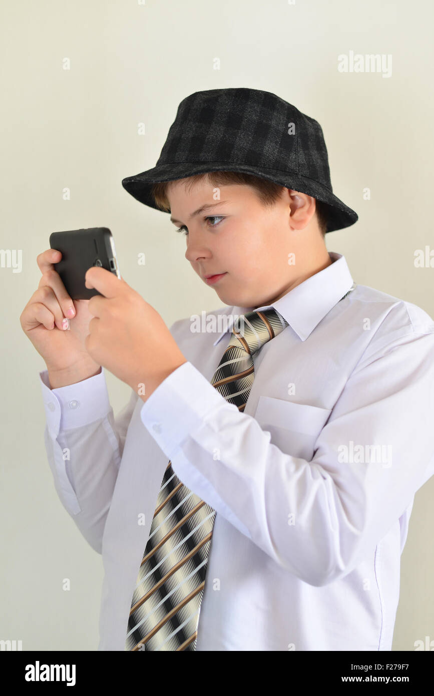 Teen boy con sorpresa guarda a un telefono cellulare Foto Stock