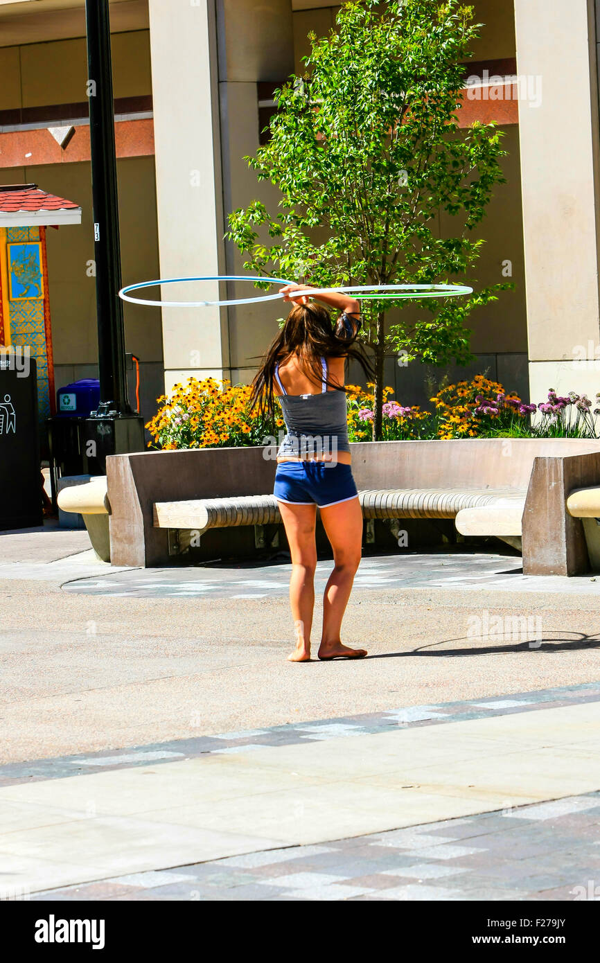 Una studentessa mettere in pratica le sue abilità con un Hoola-Hoop in downtown Madison Wisconsin Foto Stock