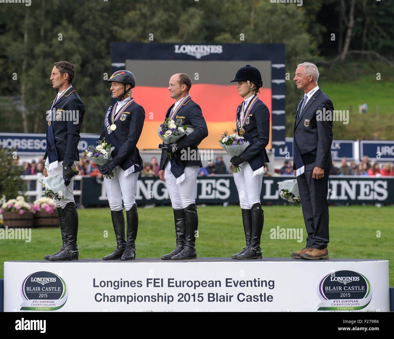 13 settembre 2015, Blair Atholl, Scozia. La medaglia d'oro winning team tedesco stand verso la loro bandiera nazionale durante l'inno dopo la presentazione delle medaglie. [L-R] Dirk Schrade, Ingrid Klimke, Michael Jung, Sandra Auffarth e Chef d'Equipe Hans Melzer. Il Longines FEI European Eventing Championships 2015 Castello di Blair. Foto Stock