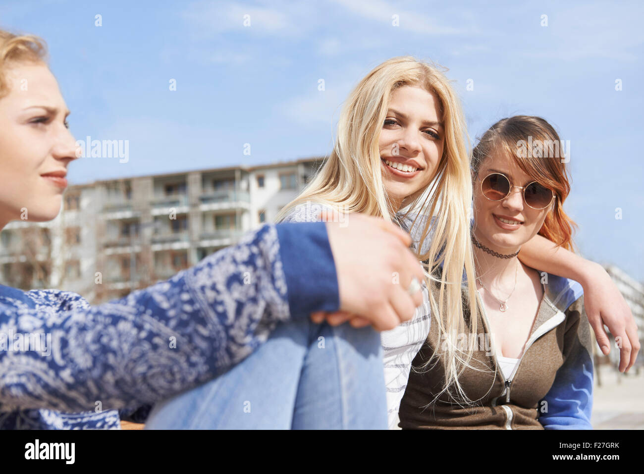 Tre amici seduti insieme in un parco giochi, Monaco di Baviera, Germania Foto Stock