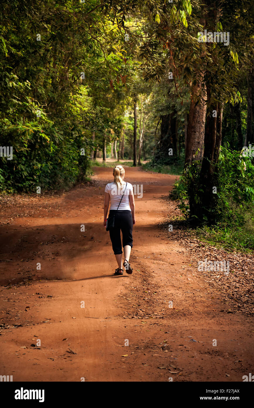Donna che cammina sulla strada di campagna Foto Stock