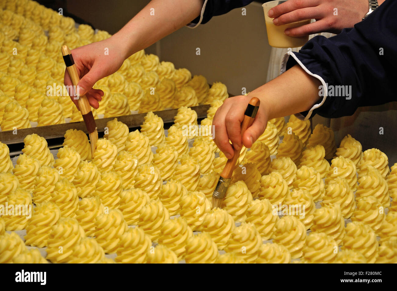 I cuochi speciale dello smalto di purè di patate piatto con olio in una grande cucina Foto Stock