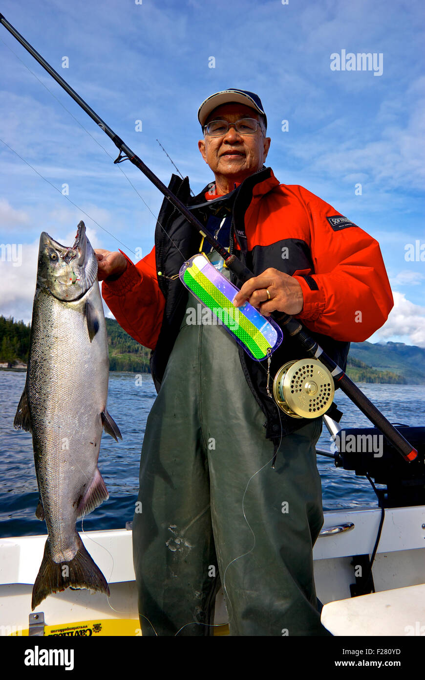 Maschio asiatico pescatore azienda sport catturato il Salmone Chinook Chatham punto Campbell River BC Canada Foto Stock