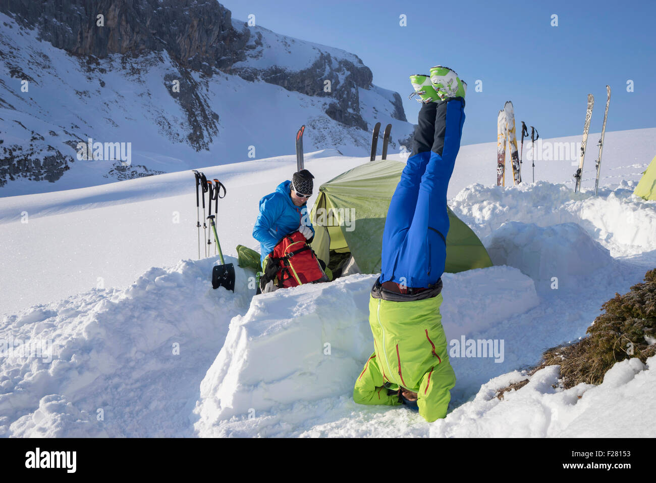 L'uomo facendo yoga headstand a camp sulle cime di montagna, Tirolo, Austria Foto Stock