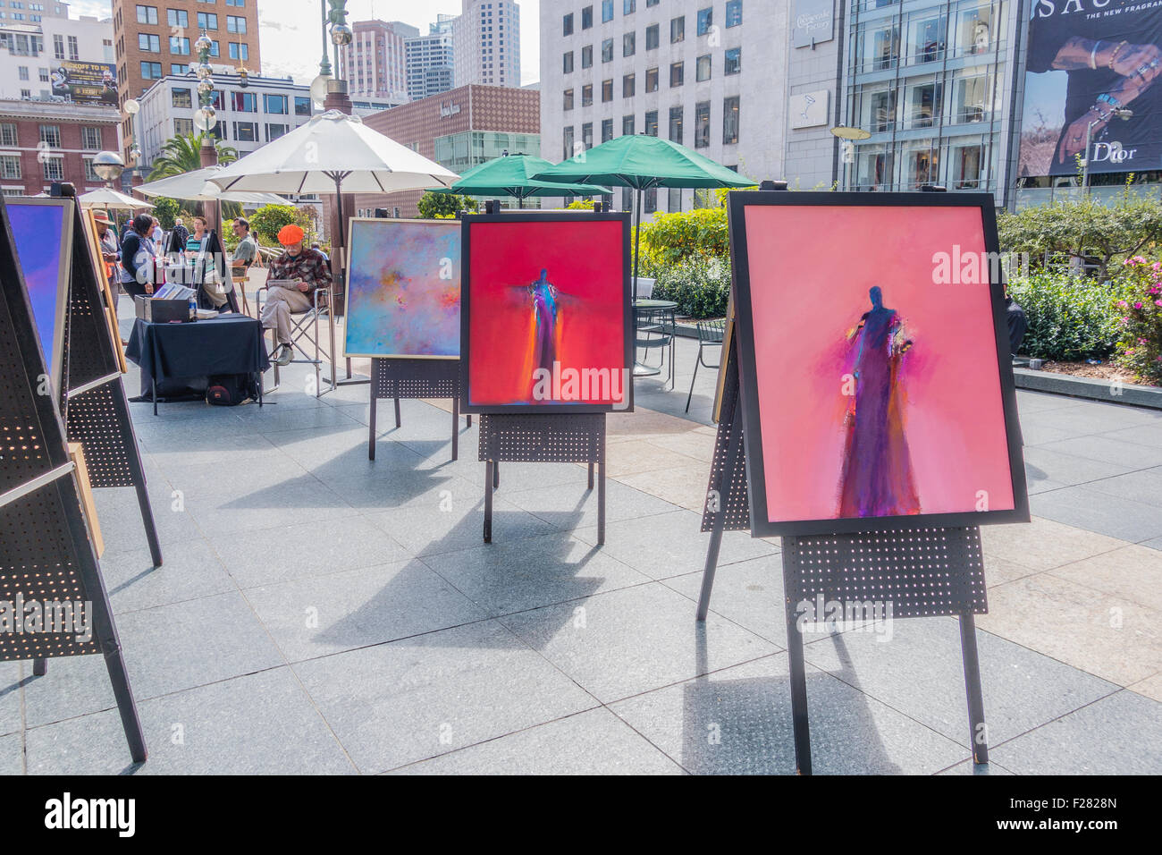 Un anziano 80-90 anno il vostro artista siede la visualizzazione di suoi dipinti in Union Square di San Francisco, California. Foto Stock