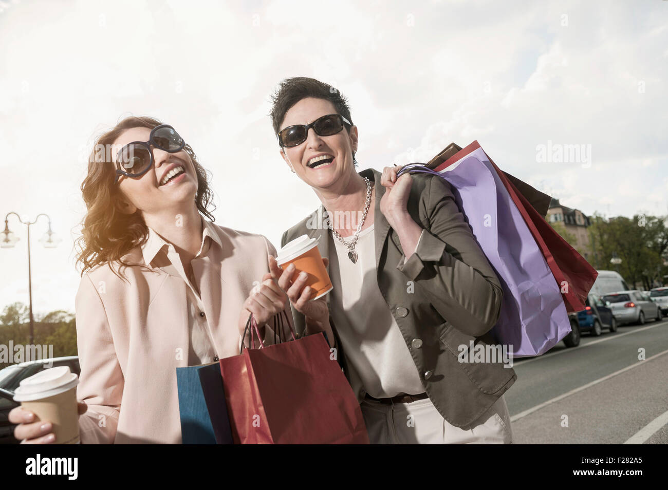 Due donne mature di shopping in città con caffè, Baviera, Germania Foto Stock