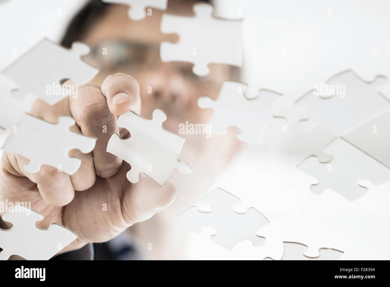 Uomo d'affari che organizza pezzi di puzzle, Baviera, Germania Foto Stock
