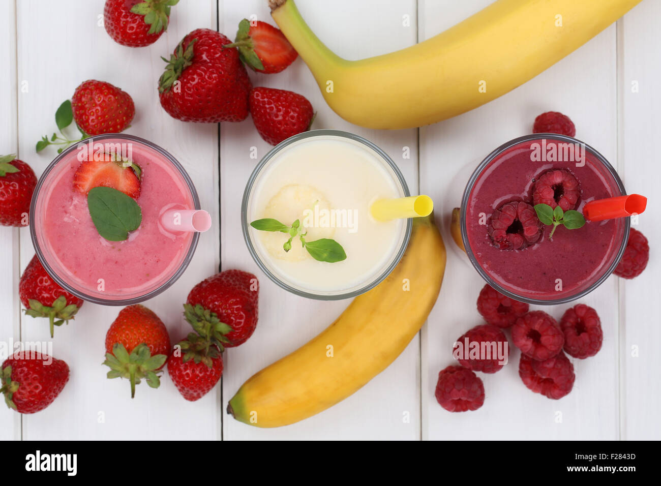 Frullato di succo di frutta con frutti come fragole, lamponi e banana in vetro dal di sopra Foto Stock