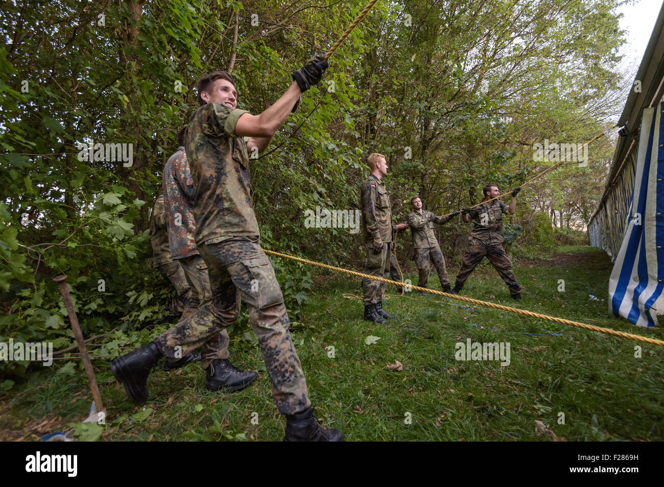 Troopers della montagna del battaglione di fanteria 232 delle forze armate tedesche allestire delle tende in Unterhaching, Germania, 13 settembre 2015. Le tende sono state impostate per ospitare temporaneamente i profughi in arrivo. Foto: Nicolas Armer/dpa Foto Stock
