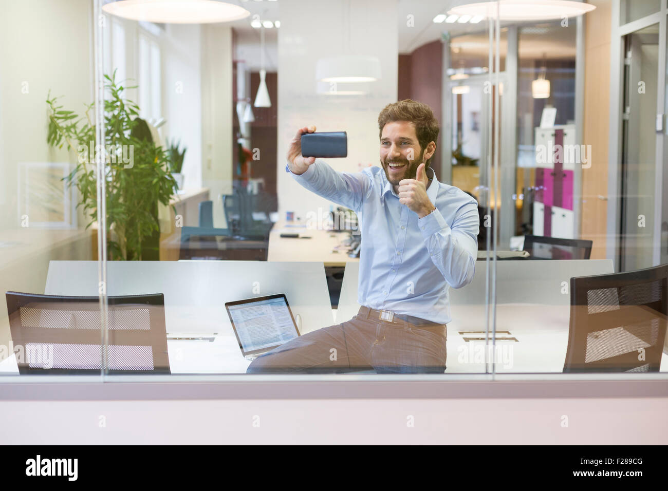 Selfie casual uomo d affari di scattare foto in open space office Foto Stock