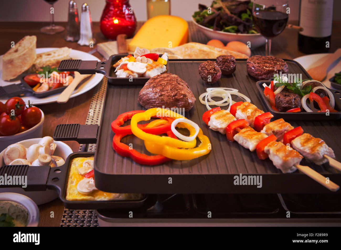 La raclette svizzera o la variante olandese "gourmetten'. Una tabella riempita con gli ingredienti per un piatto che di solito è servito sul celebrato Foto Stock