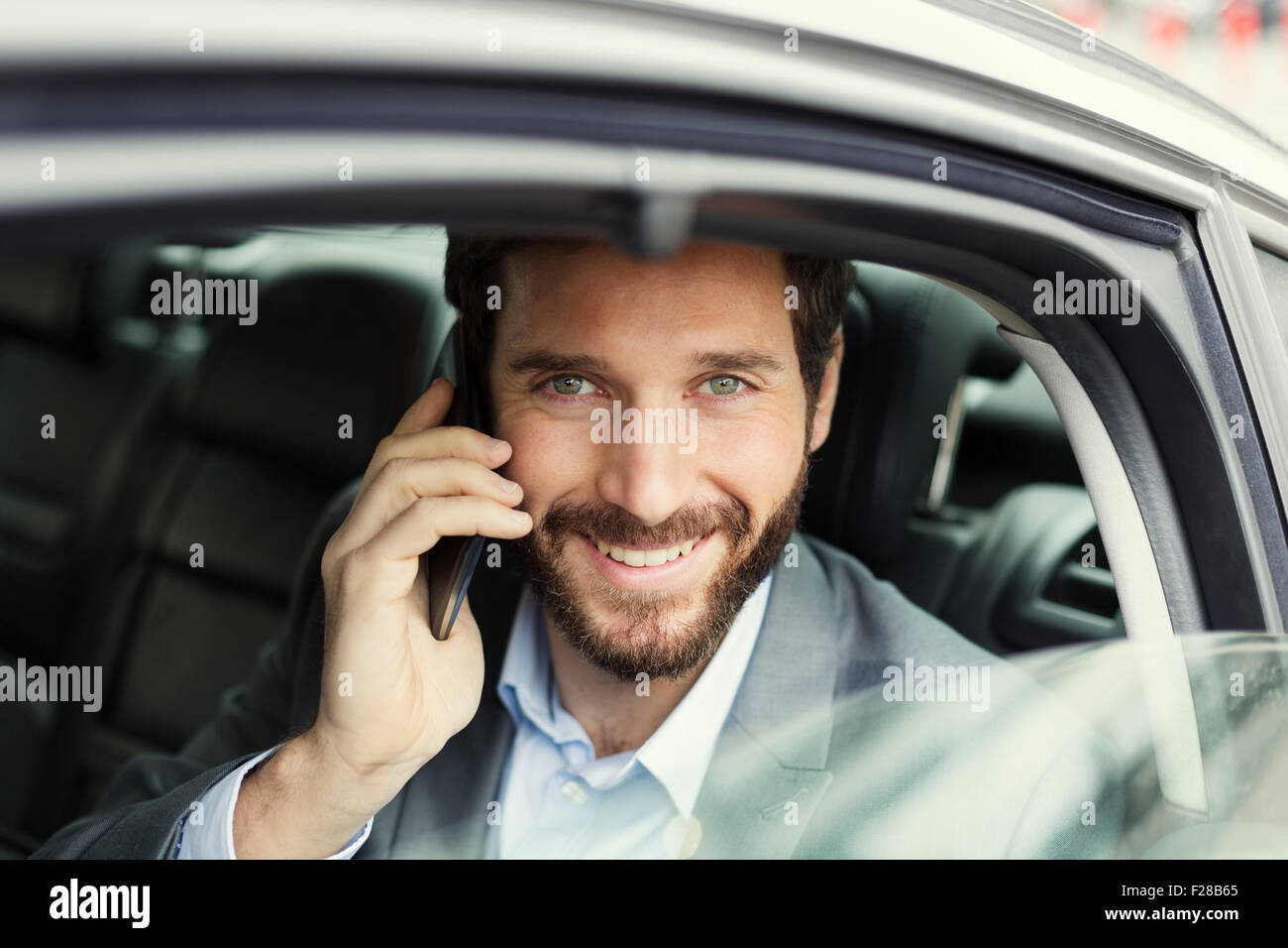 Allegro business man sul cellulare nella parte posteriore della vettura Foto Stock
