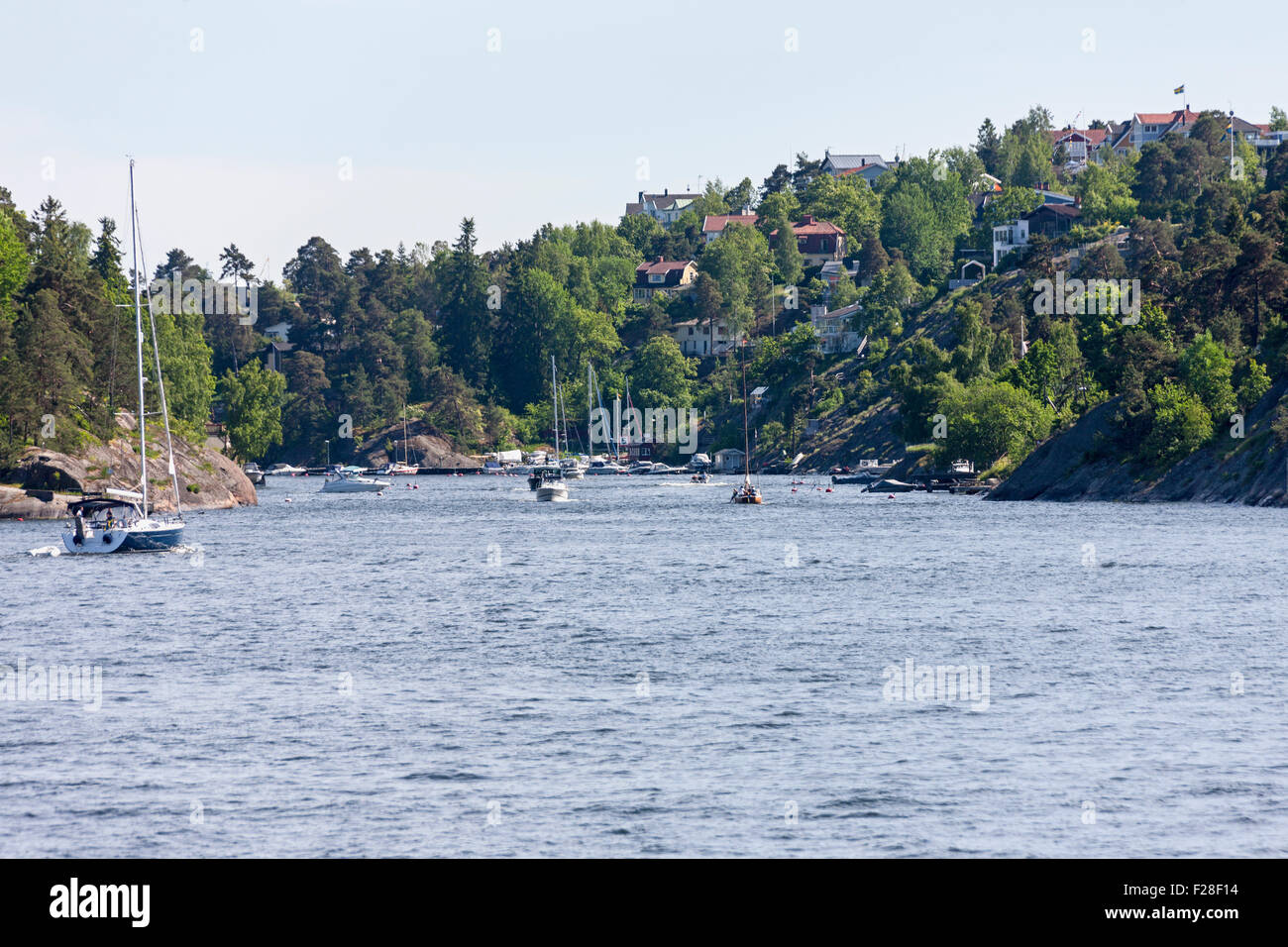 Barche a vela in mare con la città sullo sfondo, Velamsund, Stoccolma, Svezia Foto Stock