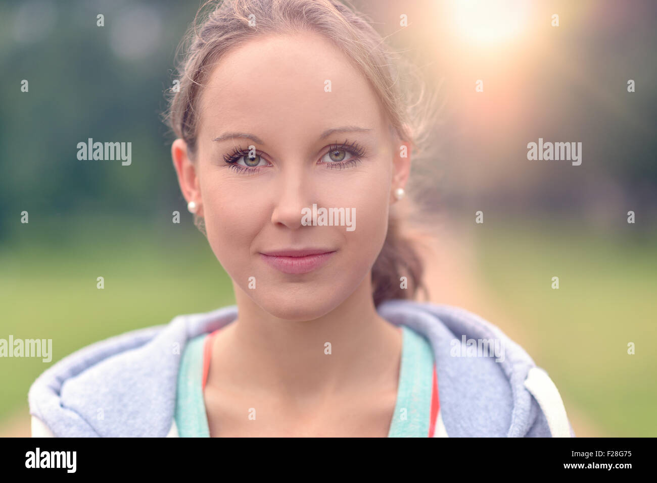 Vicino la testa e la spalla colpo di montare una giovane donna guardando la telecamera con un sorriso toothy. Foto Stock